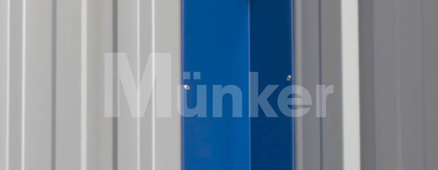 Das Bild zeigt eine Innenecke (blaues Kantteil) montiert an einer Trapezblech-Fassade