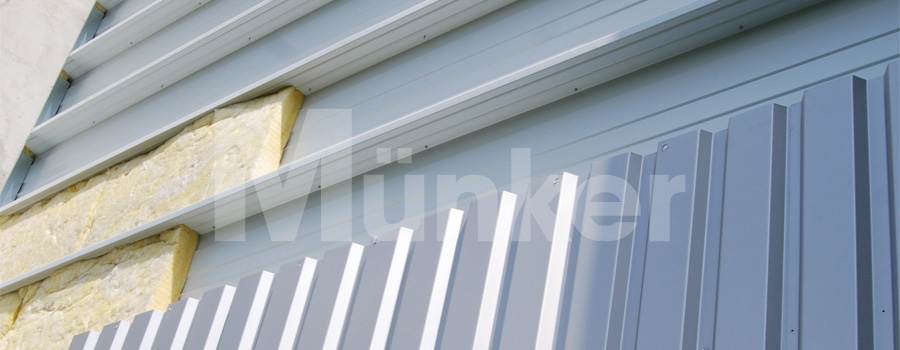 Ansicht einer Kassettenwand mit Dämmung und vorgesetzten Trapezblechen als Abschluss